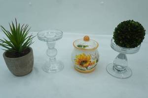 lot 292 image: Decor Lot Artificial Green Plants, Clear Glass Candle Holders, Small Ceramic Canister wLid