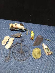 lot 47 image: Wood drink tokens, metal bicycle, metal mini fishing net, wood cat on hay trailer, parrot, fish, boat and bird