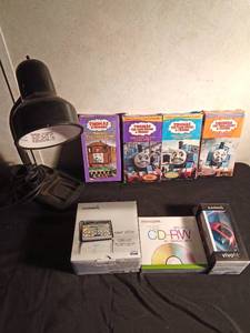 lot 65 image: Thomas the Train VHSs, 5 pack of blank CDs, GPS, FIT and a desk lamp
