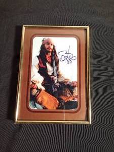 lot 107 image: Framed Photo of Captain Jack sparrow signed Johnny Depp