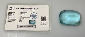 lot 104 image: OM Gems Testing Lab Natural Aquamarine 171.10 Cts. Chusion Shaped Light Blue Aquamarine (With Card)