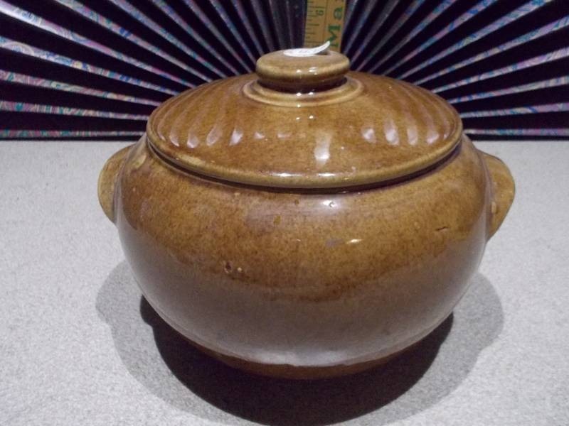 lot 42 image: This is a vintage stoneware bean pot with a lid and handles.