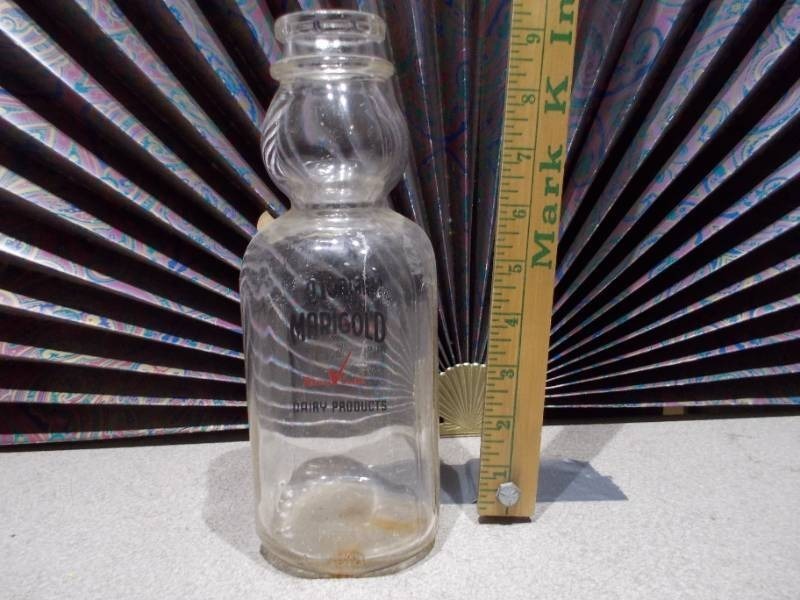 lot 46 image: This is a vintage Marigold Dairy Products clear glass milk bottle