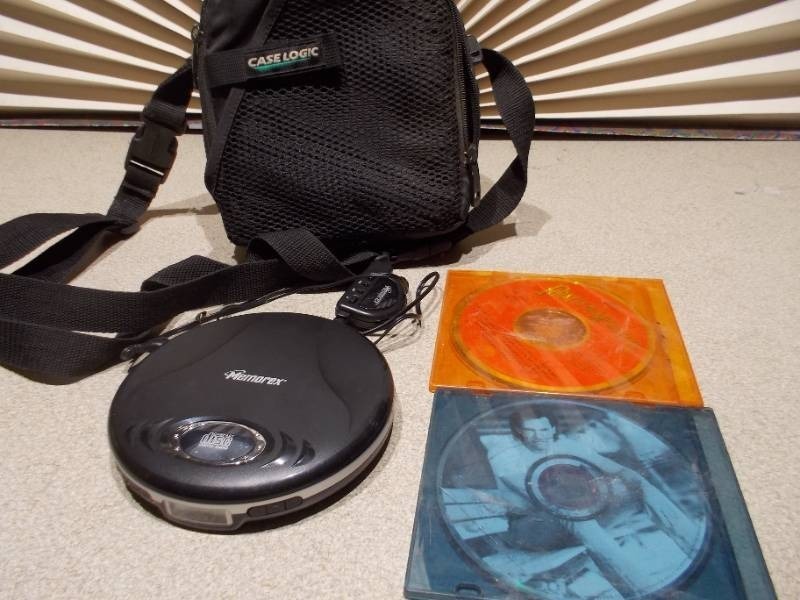 lot 86 image: This appears to be a Memorex MD6451 portable CD player along with a Case Logic carrying case and two CDs.