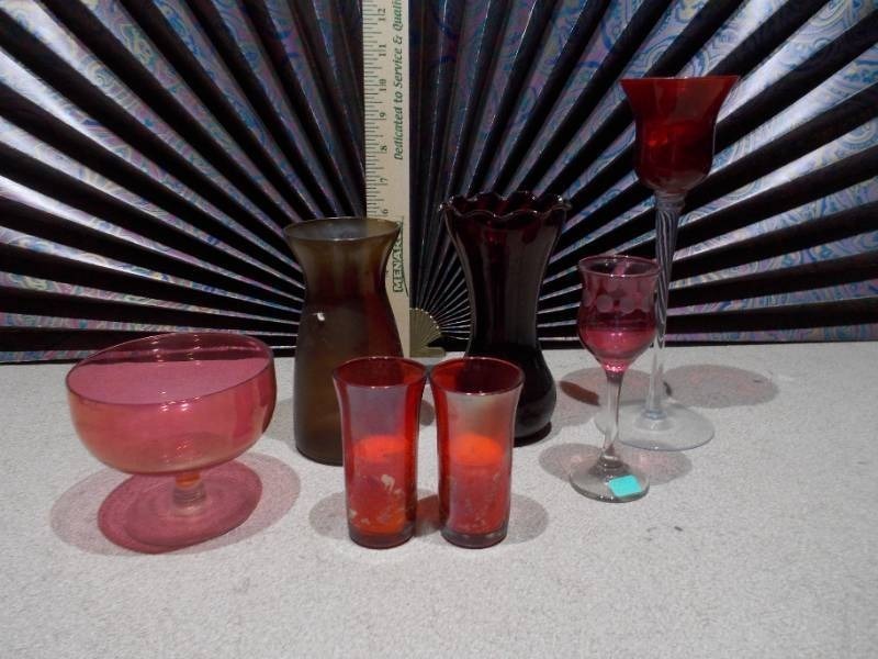 lot 120 image: This collection features various pieces of cranberry glass stemware and vases