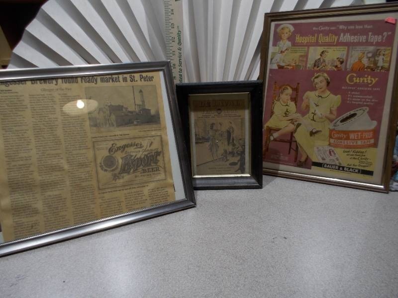 lot 130 image: The image displays three framed vintage advertisements and historical newspaper clippings.