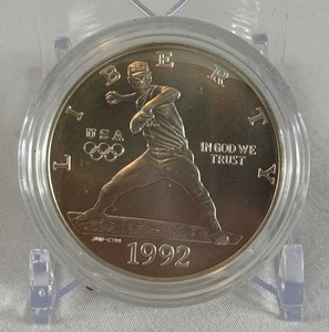 lot 40 image: 1992 D-Olympic Baseball Commemorative Uncirculated Silver Dollar - just the coin in a protective plastic case, one appears to have slight fire damage