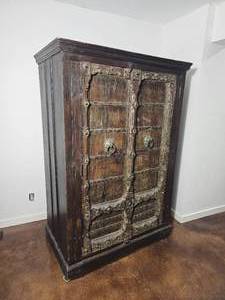 lot 23 image: Indo Inspired Rustic Armoire with Decorative Hardware