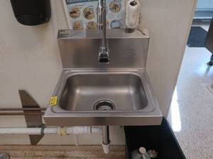 lot 211 image: STAINLESS STEEL SINK WITH A STAINLESS STEEL SHELF, AND MIRROR AND TOWEL DISPENSER
