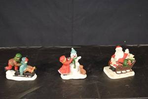 lot 244 image: Holiday Figurines Trio - Santa Sleigh, Snowman with Scarf, Sledding Kids