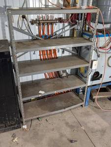 lot 86 image: Industrial Steel Shelving Rack with Top-Mounted Valve Manifold and Orange Hoses
