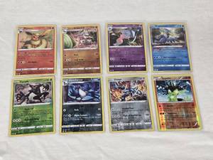 lot 206 image: Lot of 8 Holo Pokemon Cards Featuring Flareon, Zarude, Dialga, and Zygarde