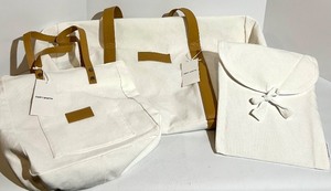 lot 128 image: Cozy Earth Canvas Tote Bags with Tan Leather Handles and a soft cream pouch