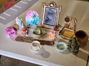 lot 82 image: Lot of Assorted Decorative Items and Trinkets including a small ceramic cat, a Florida-themed sand dollar, a decorative mirror, a painted piggy bank and more