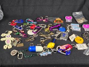 lot 345 image: Large Lot of Assorted Keychains and Accessories featuring unique designs such as a beaded lizard, miniature license plates, and themed items from Las Vegas.