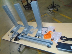 lot 52 image: Power Adjustable Corner Desk Legs See photos 3 Legs  Some Cables