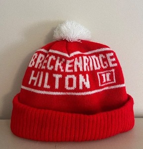 lot 69 image: Breckenridge Hilton Beanie - Red Knit Hat with White Pom-Pom