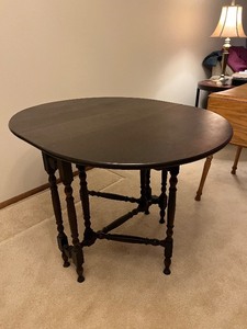 lot 194 image: Oval Drop-Leaf Dining Table - Dark Wood, 34 in Diameter, Turned Legs