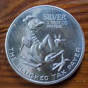 lot 311 image: Excellent Bullion Coin (BU) .999 Fine Silver  USA   World Trade Unit, �Plucked Tax Payer�