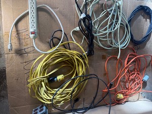 collection of various electrical extension cords and a power strip
