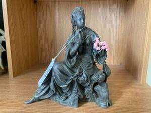 Bronze-colored seated woman figure...