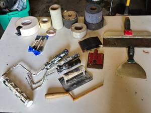Drywall Tools and Supplies including Rolls of Tape, Trowels, and Sanding Tools