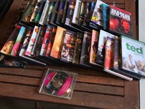 Lot of DVDs and CDs including Ted, Last Man Standing, and Journey to Adventure CD-ROM