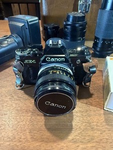 classic Canon AE-1 35mm film photography kit with several compatible accessories