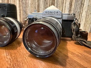vintage Konica 35mm SLR film camera with multiple lenses