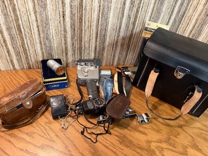 The image displays a collection of vintage cameras and photography accessories, look close at these gems 