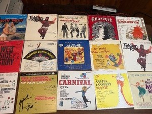Vintage  LP collection featuring classic titles such as Fiddler on the Roof, Camelot, Oklahoma, The Unsinkable Molly Brown, Flower Drum Song, Godspell, and Hans Christian Andersen, along with original cast and film recordings.