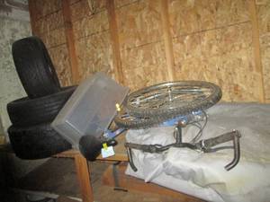 Contents of a shelf including tires, Huffy bike and more