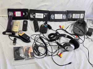 Various Electronics and Accessories Including VHS Tapes, Remotes, and Headphones