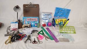 Office supplies including lamp, scissors, rulers, pens, and stencils