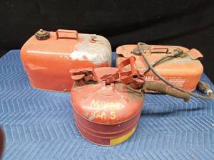 2 metal gas cans and 1 Yamaha boat gas tank