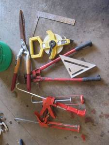 Lot of hand tools including a bolt cutter, measuring tape, squares and more