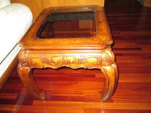 Ornate end table made of solid wood with a glass top.  Measures 28 x 24 x 28.  Matches lot 302 and 303