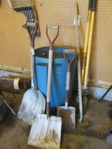 Lot of yard tools in a blue barrel