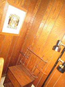 Small wood bedside table and wood shelf, framed art and a floor lamp