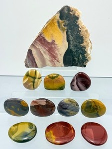 Mookaite Jasper is a unique Australian gemstone formed from ancient fossilized sea creatures that is prized by collectors for its vibrant, porcelain-like colors found in both raw slabs and smooth palm stones.