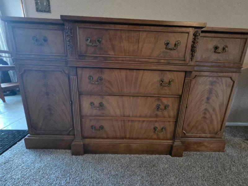 Wooden credenza featuring ornate brass hardware