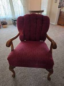 Vintage upholstered armchair featuring a carved wood frame