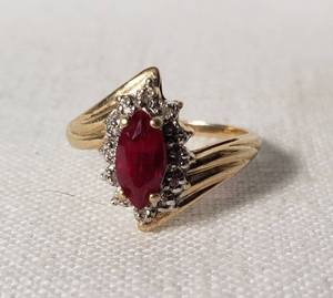 Gold Ring with Marquise-Cut Red Gemstone and Accent Stones The band is marked with 10K, indicating 10 karat gold