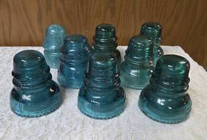 Eight Vintage electric line insulators most likely produced by the Hemingray Glass Company.  Aqua-blue color is characteristic of early 20th century glass manufacturing.&nbsp&nbsp