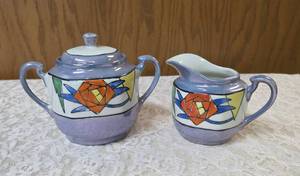 Vintage Art Deco Japanese Lusterware creamer and sugar bowl set.  Features a hand-painted iridescent glaze with a stylized abstract floral or geometric pattern.  Produced in Japan likely between 1921-1941.&nbsp&nbsp