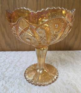 Vintage Imperial Carnival Glass compote or candy dish in a marigold (iridescent orange) color featuring a pedestal base and a Hobstar and Arches pattern. 7 to 8 tall.&nbsp