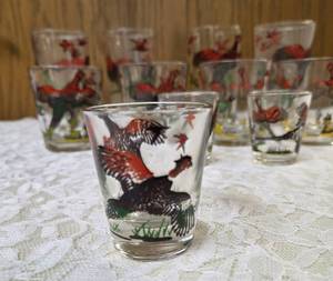 11 -Glasses - Misc., sizes.  Glassware is likely produced by the Hazel-Atlas Glass Company and  features the Pheasants pattern, produced roughly 1950s. The glasses feature the yellow hunting dogs and red flying birds.&nbsp