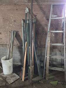 Assorted Metal Fence Posts, Wooden Ladder, and Garden Stakes