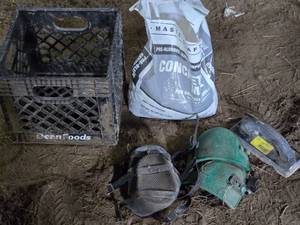 Partial Bag of Concrete Mix, Knee Pads, and Trowel with Milk Crate