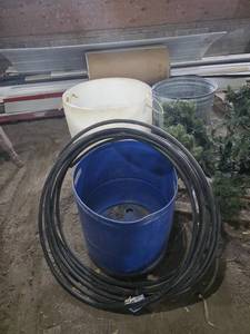 Blue and White Plastic Barrels, Metal Bin, and Black Hose